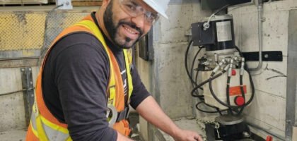 Technicien ajustant le système hydraulique d'un nivelateur de quai de chargement avec une clé anglaise