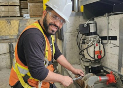 Technicien ajustant le système hydraulique d'un nivelateur de quai de chargement avec une clé anglaise